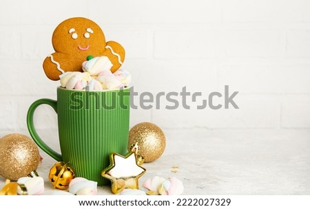 Christmas gingerbread cookies and a cup of hot chocolate with marshmallows on a light background. Festive food. Christmas concept. Copy space.