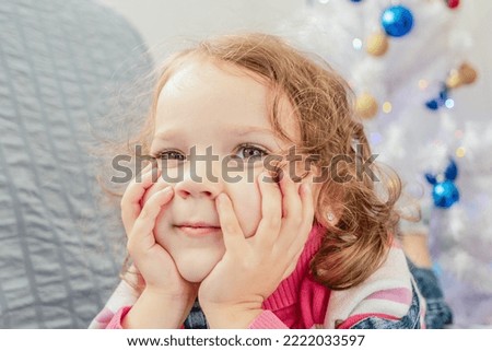 A smiling child on the background of a Christmas tree. Holidays and events.