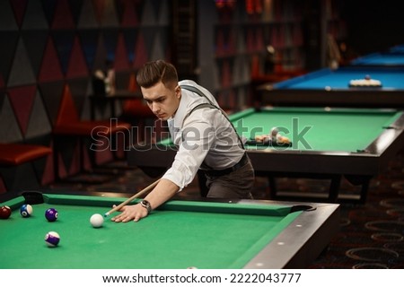 Portrait of man playing billiards Royalty-Free Stock Photo #2222043777
