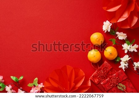 Chinese New Year 2023 festival decorations, mandarins, flowers, envelopes on red background. Flat lay, top view.
