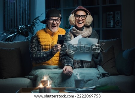 Happy couple finding the best energy deals online and saving money on their utility bills, they are comparing services and tariffs online on their smartphone Royalty-Free Stock Photo #2222069753