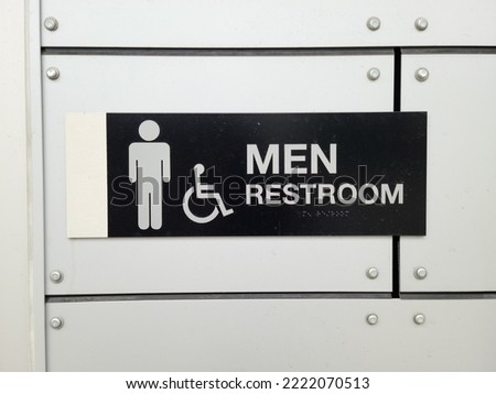 Male toilet sign on white wall front view
