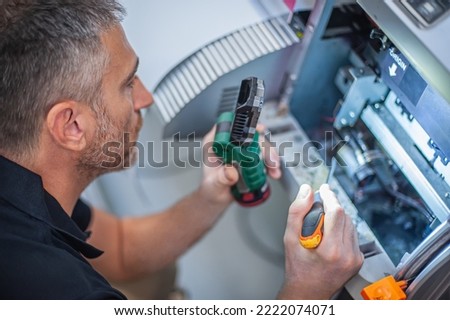 All machines nead maintains. Professional technician troubleshooting and repair the machines in the printing house. Royalty-Free Stock Photo #2222074071