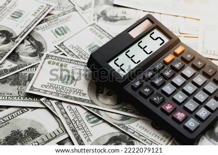 Calculator with the word FEES on the calculator placed on the dollar, concepts, fees, fees services and taxes. Royalty-Free Stock Photo #2222079121