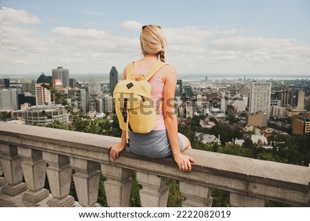 Blonde woman looking at Montreal downtown skyline cityscape. Canada.