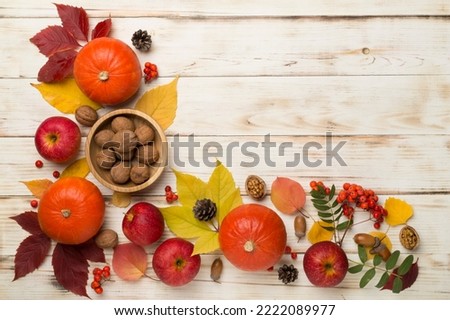 Festive autumn flat lay with pumpkins, berries and leaves on a wooden background, top view.