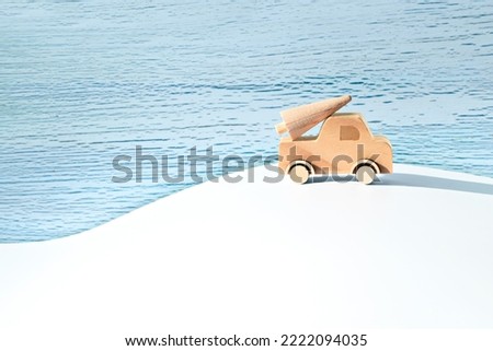 Wooden toy, silhouette of Christmas tree on toy car on off white and mint green background. Xmas holiday, snow background. Copy-space, place for text, greeting. Simple, minimal design for Xmas banner.