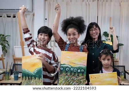 Group of art people in classroom studio, a teacher and student kids proud show painting work, an acrylic color picture on canvas, creative learning with talents skill at elementary school education. 