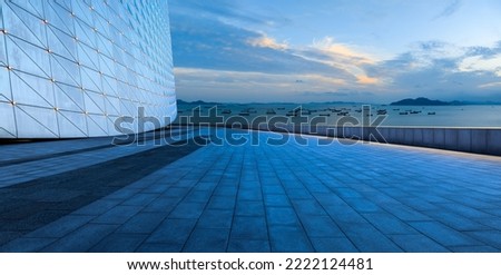 Empty square floors and glass walls with sea natural scenery at dusk in Zhoushan, Zhejiang, China. Royalty-Free Stock Photo #2222124481