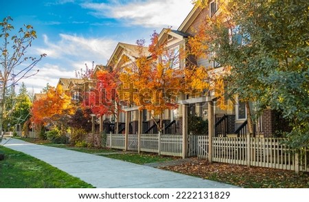 Quite and colorful sidewalk at residential area in British Columbia Canada. Beautiful fall foliage and row of single-family houses. Beautiful autumn colors. Nobody, street photo Royalty-Free Stock Photo #2222131829