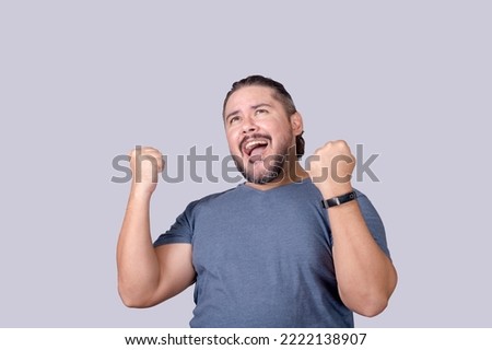A man shouts in elation. Overjoyed man celebrating victory, pumping his fists. Isolated on a gray background. Royalty-Free Stock Photo #2222138907