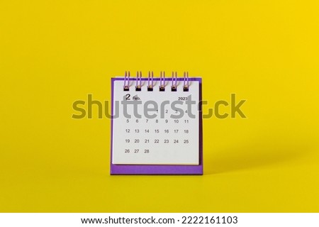 Desktop calendar for February 2023 on a yellow background