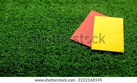 Red and yellow card on a soccer field.