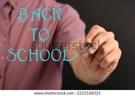 Man hand writes inscription on the screen isolated on black background. High resolution photo. Concept of school education