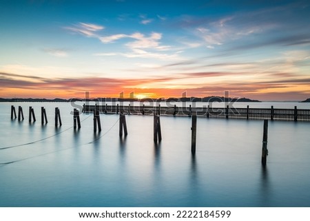 Poles standing in water at empty harbour Royalty-Free Stock Photo #2222184599