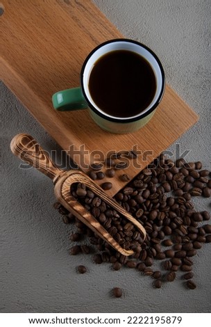 Green cup of coffee with coffee beans,top view
