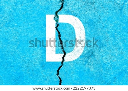 Letter D background with blue color painted on broken wall with cracks