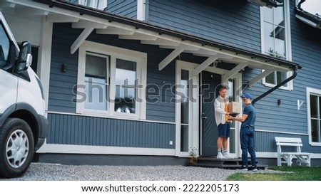 Handsome Young Homeowner Receiving an Awaited Parcel from a Cheerful Courier. Postal Service Worker Comes to the House to Make a Door to Door Delivery and Get a POD Signature on Tablet. Royalty-Free Stock Photo #2222205173