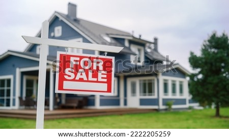 For Sale Sign on a Lawn in Front of a Modern House with Traditional Design. Real Estate Property, Mortgage, Housing Market and Home Ownership Concept.