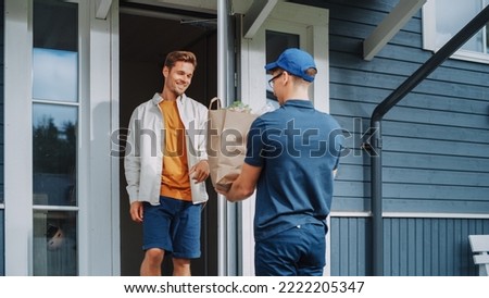 Young Man Working in a Grocery Delivery Service, Bringing a Brown Paper Bag Full of Fresh Vegetables and Other Food Items to a Residential Area Home. Happy Addressee Opens the Door and Signs a POD.