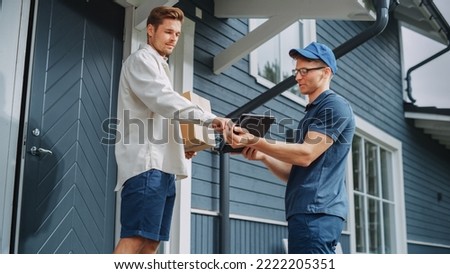 Handsome Young Homeowner Receiving an Awaited Parcel from a Cheerful Courier. Postal Service Worker Comes to the House to Make a Door to Door Delivery and Get a POD Signature on Tablet. Royalty-Free Stock Photo #2222205351