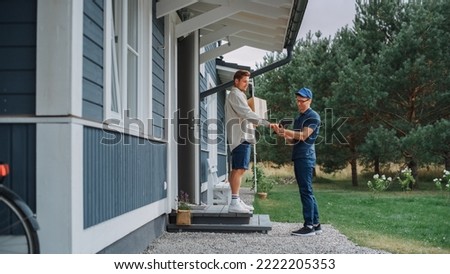 Handsome Young Homeowner Receiving an Awaited Parcel from a Cheerful Courier. Postal Service Worker Comes to the House to Make a Door to Door Delivery and Get a POD Signature on Tablet. Royalty-Free Stock Photo #2222205353