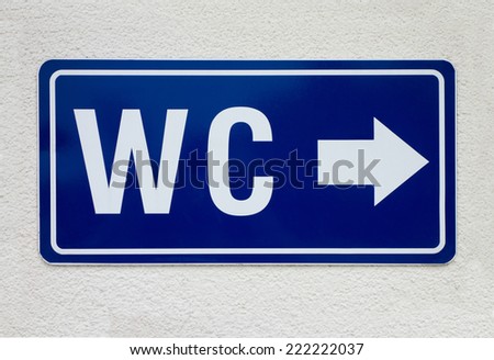 Blue sign with arrow for public toilet