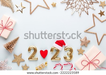 New year 2023 number, golden digits and santa hat over blue background.