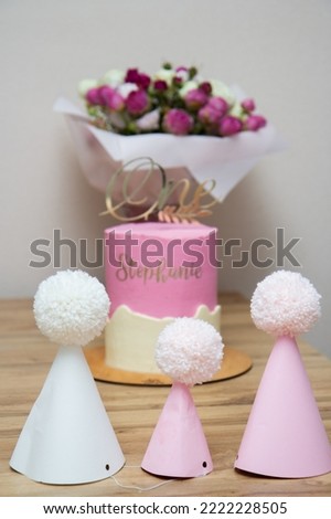pink paper caps, pink cake and a bouquet of flowers