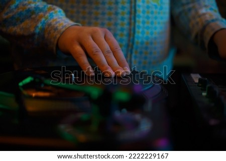 Hip hop dj scratching vinyl record on turntable. Download stock photo of disc jockey playing music on concert. Professional disk jokey scratches records on turntables in night club