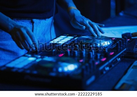 Female dj playing music set on night club party. Disc jockey woman plays hip hop on concert in nightclub. Download stock photo of disk jokey girl mixing musical tracks on stage