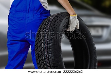 male tire changer In the process of checking the condition of new tires that are in stock to be replaced at a service center or auto repair shop Tire depot for the automobile industry.