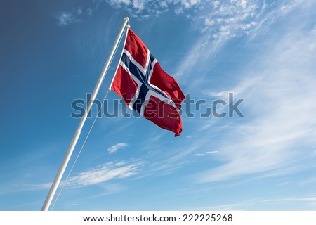 Flag of Norway on the blue sky background. Royalty-Free Stock Photo #222225268