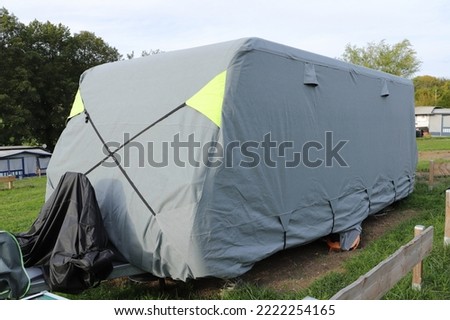 a caravan with a gray tarpaulin Royalty-Free Stock Photo #2222254165