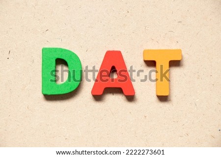 Color alphabet letter in word DAT (Abbreviation of Delivery at Terminal) on wood background