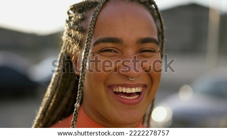 Happy millennial adult girl laughing and smiling. Portrait face closeup of a young hispanic latin South American woman real life authentic laugh and smile