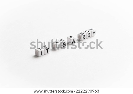 Gender reveal. It is a boy text on a perspective diagonally of the image. White plastic letter cubes placed on white background.