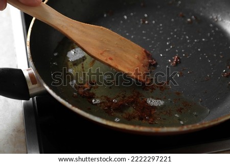 Frying pan with spatula and used cooking oil on stove, closeup Royalty-Free Stock Photo #2222297221