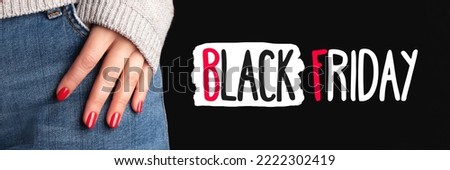 Black Friday sign on black background with female hand with beautiful manicure - red nails on jeans denim textile banner. Wide panoramic header. Shopping concept