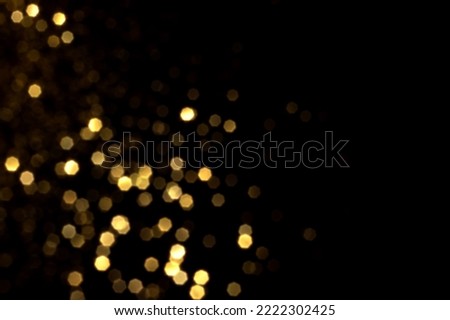 Golden blurred bokeh lights on black background. Glitter sparkle stars for celebrate. Overlay for your design Royalty-Free Stock Photo #2222302425
