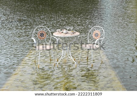 Chairs and coffee table with tea cups and glasses in water in Da Lat