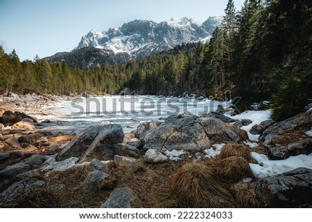 This is the picture of natural view of mountains with snow and storms and line of trees cover the moutains