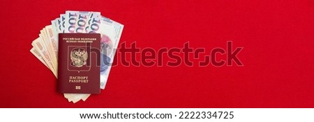 Horizontal banner with Russian biometric passport, Georgian cash and cash rubles on red textile background. Paper banknotes in documents. Relocation to Georgia from Russia due to mobilization. Bill