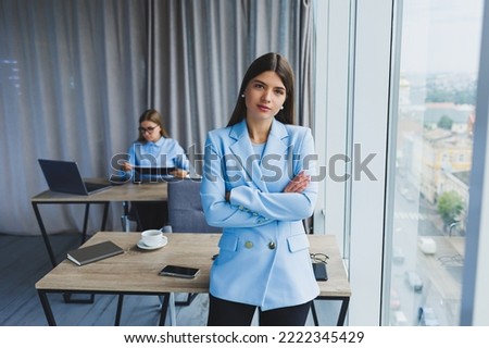 European businesswoman while working in the office. Young serious Millennial brunette woman in a jacket. The concept of freelance and remote work. Modern women's lifestyle Royalty-Free Stock Photo #2222345429