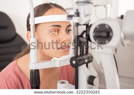 Vision, ophthalmology and woman in eye exam with light on iris at eye doctors office. Healthcare, medical insurance and eyes, girl getting healthy visual refraction eye test at ophthalmologist clinic Royalty-Free Stock Photo #2222350265