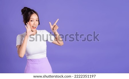 Portrait of a beautiful Asian woman posing on a purple background Royalty-Free Stock Photo #2222351197