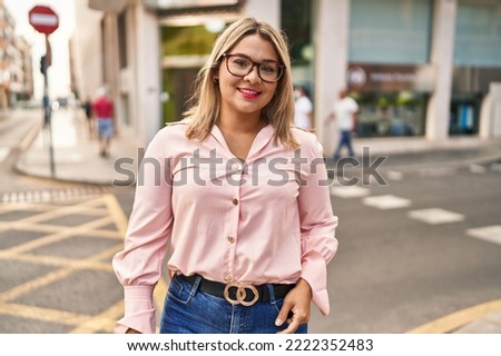 Young hispanic woman smiling confident standing at street