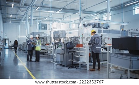 Industrial Factory: Team of Engineers, Technicians and Workers, Working on Production Plant, Developing CNC Parts, Programming Machines. Two Specialists Discussing Project Plan and Using Laptop. Royalty-Free Stock Photo #2222352767