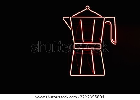 Red neon sign from lamps in the form of a Moka pot coffee maker on the wall of a black coffee shop