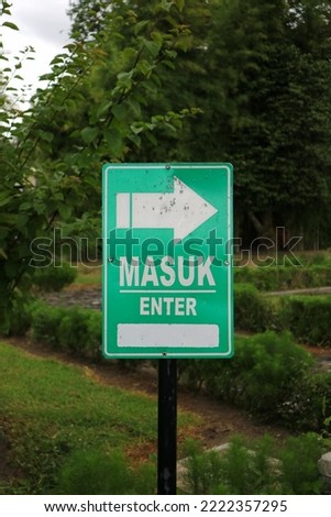 Masuk or enter signboard at the garden, park or outdoor. Green and white color. 